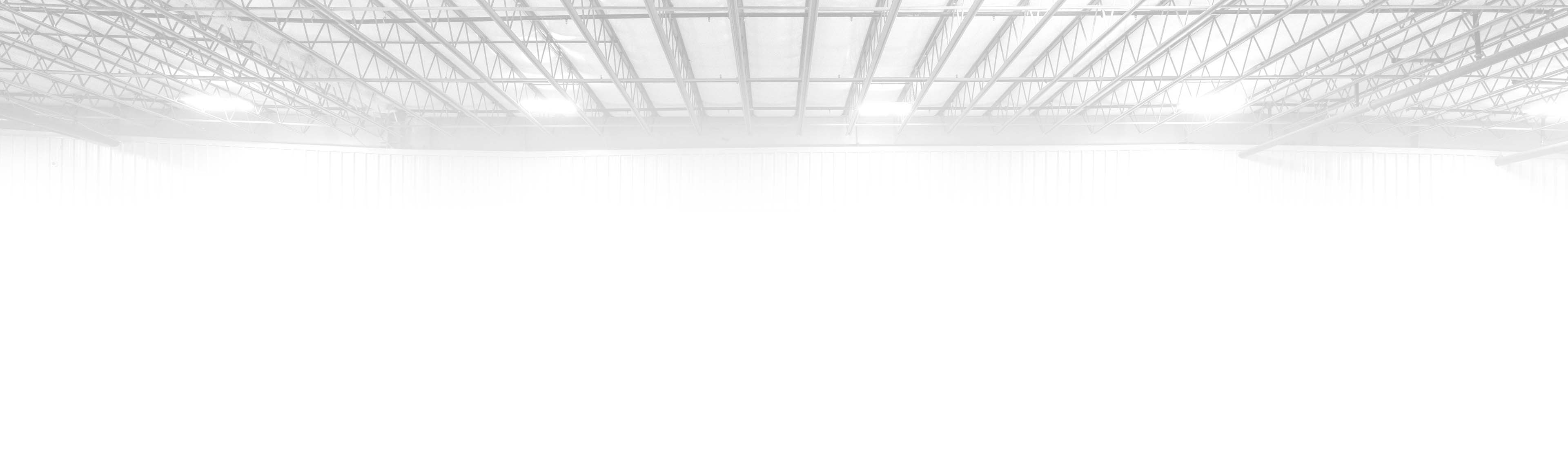 A black and white view of the rafters of a warehouse.